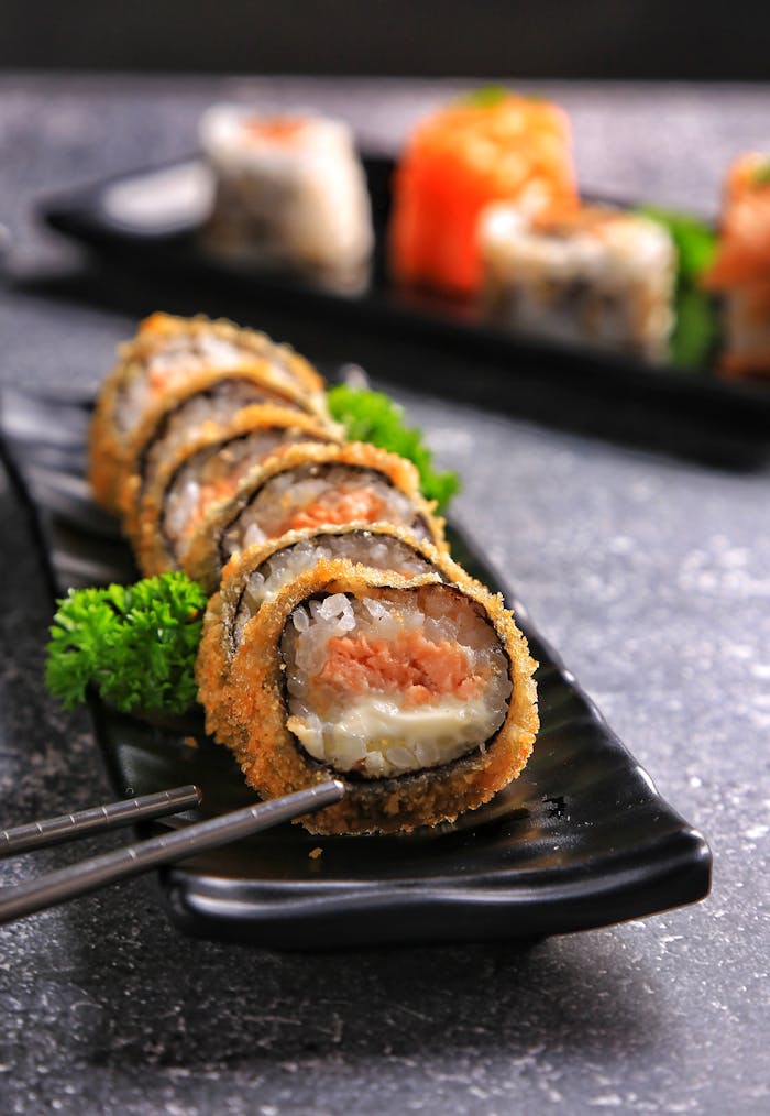 Delicious crispy sushi roll served neatly on a plate with chopsticks.